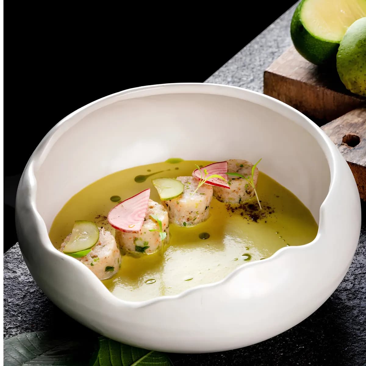 Seared scallops in herb butter served in a white bowl